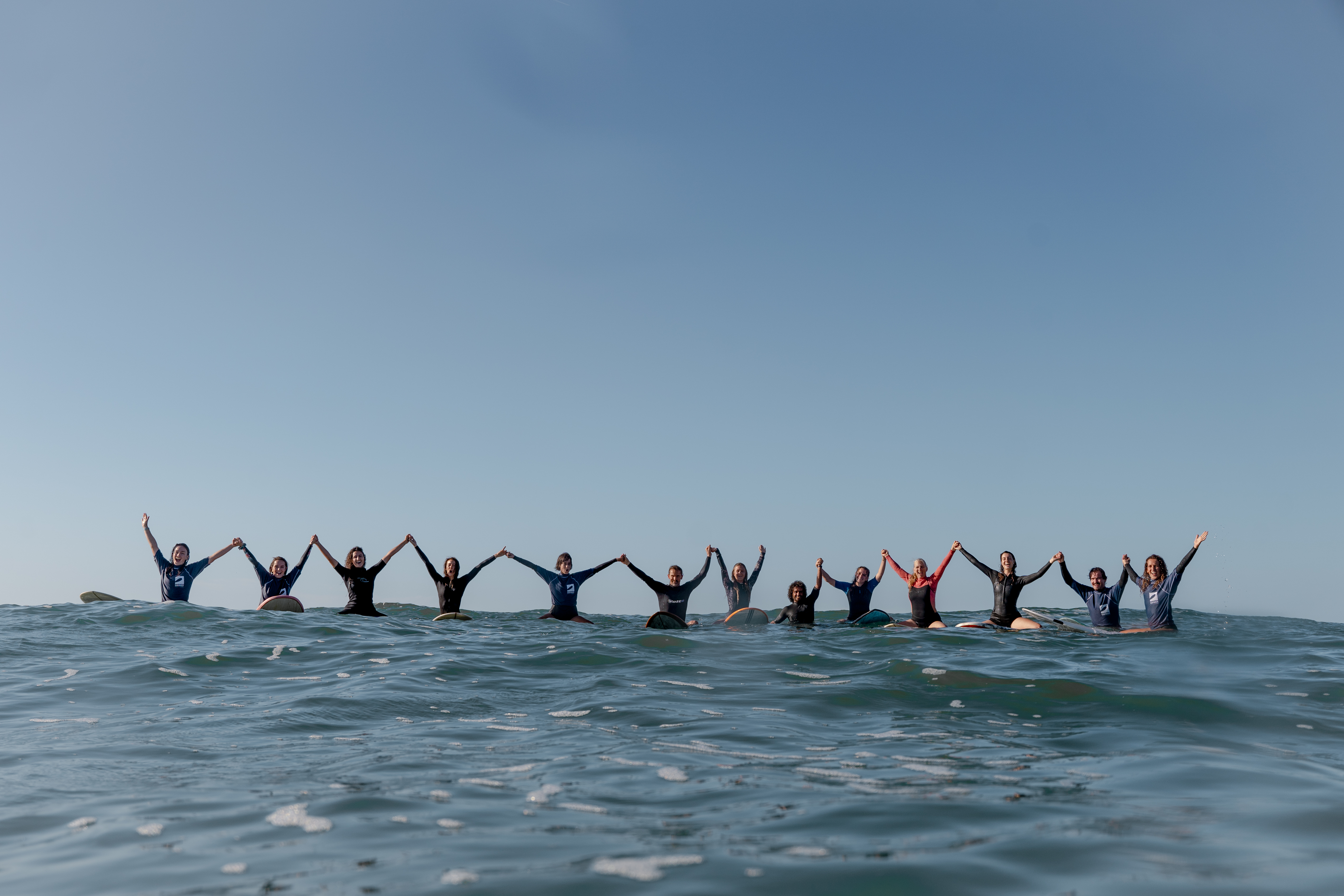 surfeurs se tenant la main sur leur planche